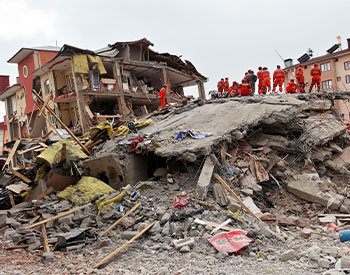 Search and rescue forces search through a destroyed building